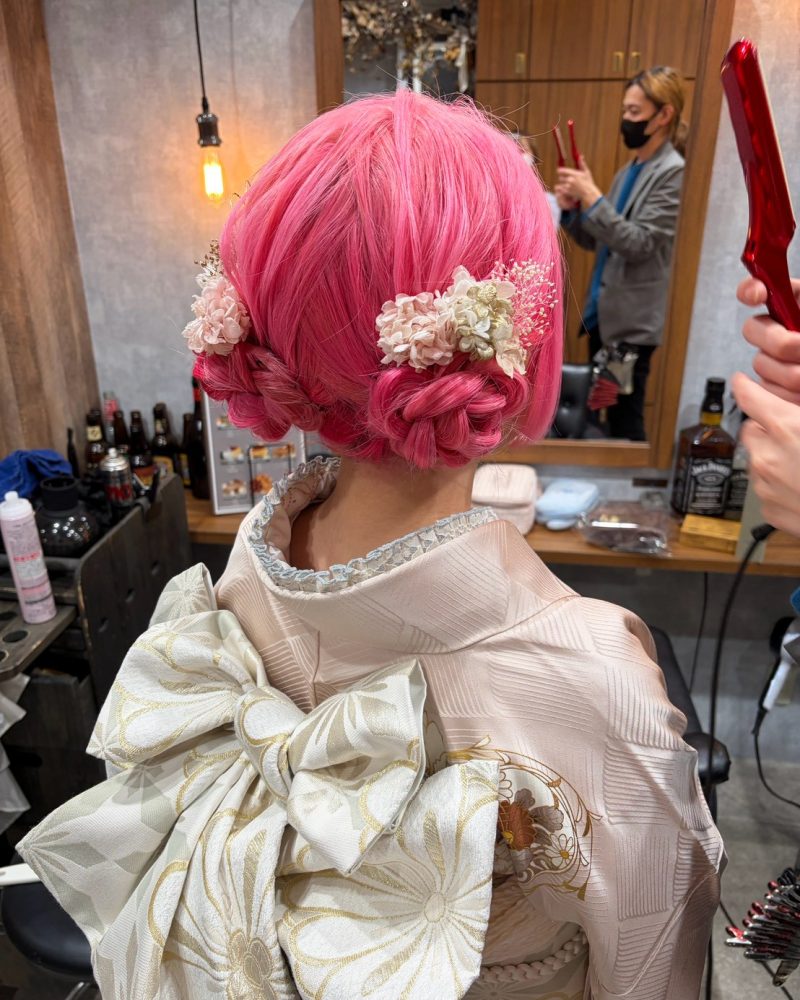 ピンクヘアが主役のツインシニヨン❤️
ヘアカラーからこの日のために！ピンクヘアを最大限に活かした、個性派ツインスタイル。淡いお花とレースの小物を合わせることで、派手すぎず甘い雰囲気に仕上げています。